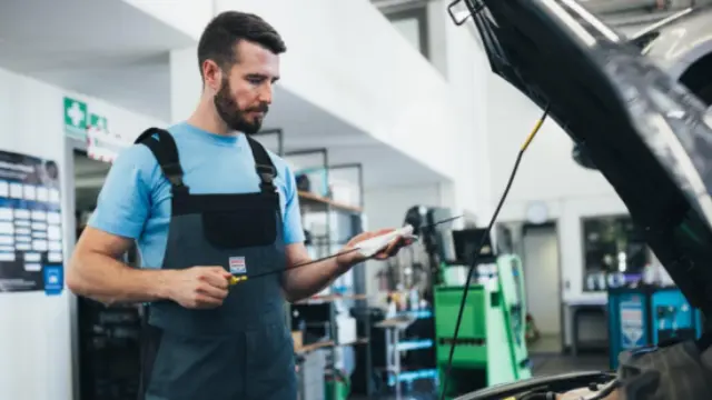 Öl wird über Trichter in den Motorraum gefüllt