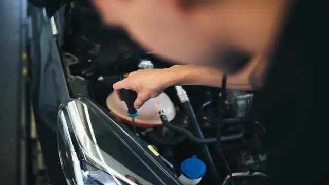 Mechatroniker prüft Scheinwerfer mit Bosch-Prüfgerät
