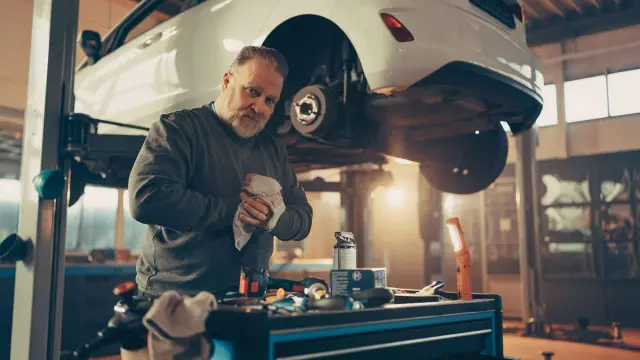 Bremsen Service in einer Werkstatt mit Auto und Mechatroniker