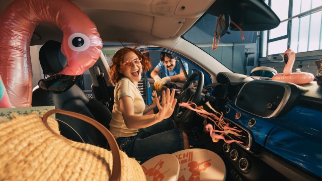 Frau in Auto mit Sommerurlaubsausstattung